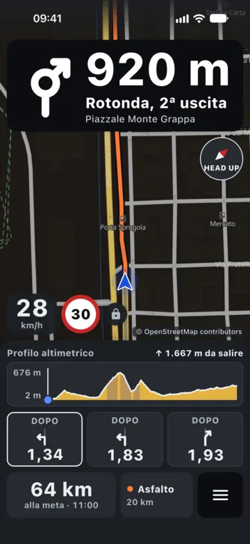 Guida di notte con colori scuri: rotonda tra 920 m, 28 km/h con limite 30, profilo altimetrico e svolte successive.
